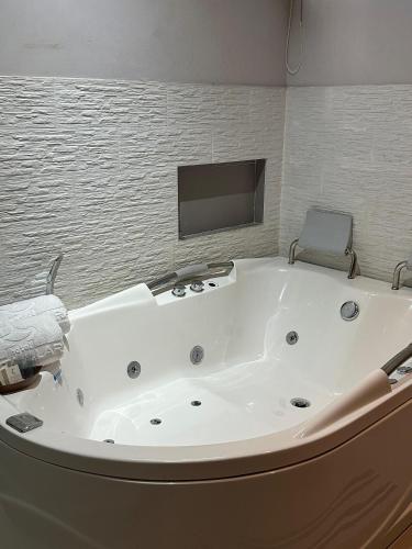 a large white bath tub in a room with a tv at Hotel Santa Clara Boutique in Montería