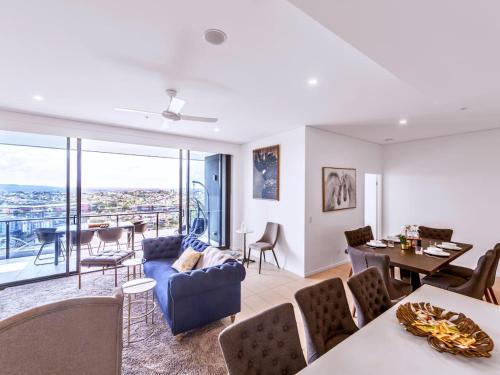 a living room with a blue couch and a table at Spacious 2Bed Apartment plus Nook with River View in Brisbane