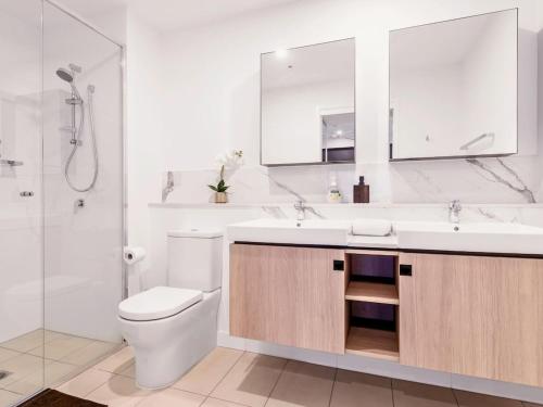 a bathroom with a toilet and a sink and a shower at Spacious 2Bed Apartment plus Nook with River View in Brisbane
