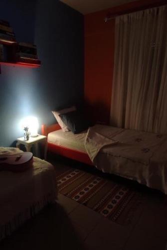a room with two beds and a table with a lamp at Mandarini in Chios