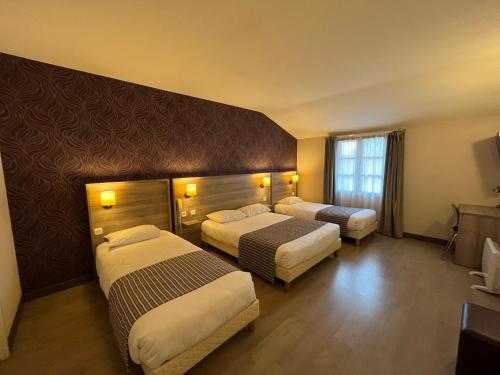 une chambre d'hôtel avec deux lits et une télévision dans l'établissement Logis Hôtel Le Saint Georges, à Vivonne