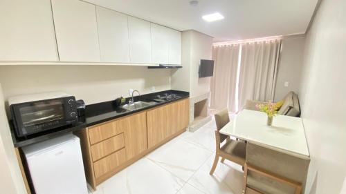 a small kitchen with a sink and a microwave at HOTEL BARLOS ADUANA in Uruguaiana