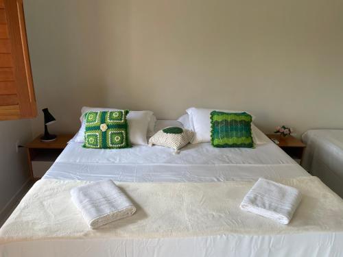 a white bed with three pillows on top of it at Pousada Sitio Parque dos Lençóis in Barreirinhas