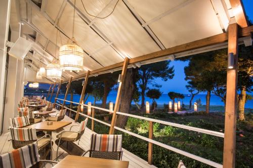 a restaurant with tables and chairs and a view of the ocean at Karystion Hotel in Karistos