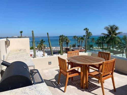 a patio with a table and chairs and the beach at Baja Mar Apartments - Ubicacion 10 in La Paz