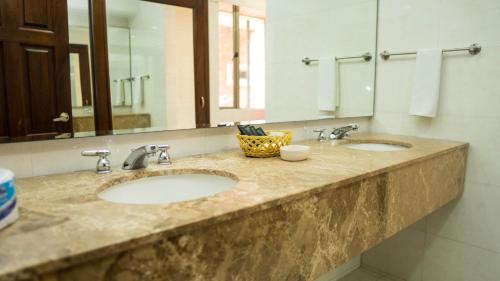 a bathroom counter with two sinks and a mirror at Hotel Windsor Barranquilla in Barranquilla