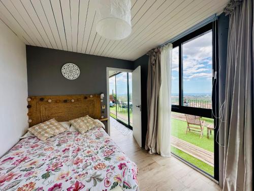 ein Schlafzimmer mit einem Bett und einem großen Fenster in der Unterkunft Home Mirador Castellvell in Castellvell