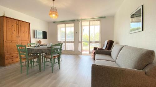 un salon avec un canapé, une table et des chaises dans l'établissement Appartement 2 pièces proche Thalasso Roscoff, à Roscoff