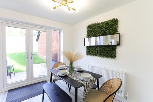 ein Esszimmer mit Tisch und Stühlen und einem Fenster in der Unterkunft Modern 4BR House in the Centre Spacious & Ideal for Families and Contractors in Lawley Bank