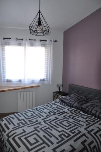 une chambre avec un lit avec une couverture noire et blanche dans l'établissement Appartement T2 proche forêt et plages, à Anglet