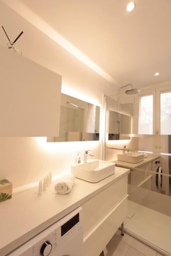 une salle de bain blanche avec deux lavabos et un miroir dans l'établissement Le Nine - Apt 2 prs standing Vieil Antibes, à Antibes
