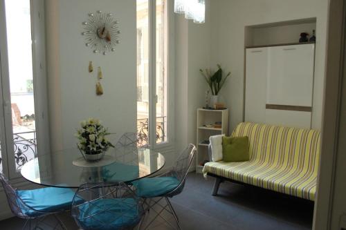 un salon avec une table en verre et un canapé dans l'établissement Appart Le Carré D'Or, à Nice