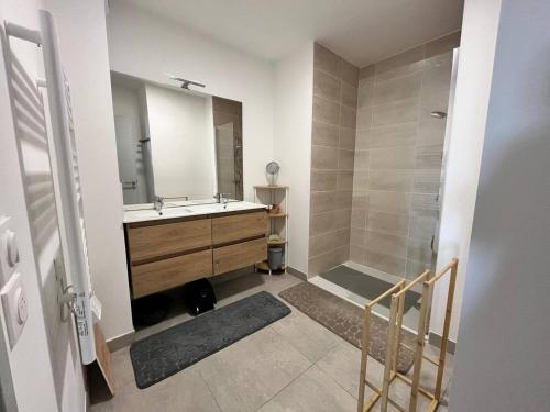 une salle de bain avec un lavabo et une douche dans l'établissement Naïa Lab, à Sérignan