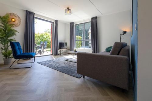 a living room with a couch and a chair at Holiday home for the whole family in Ewijk