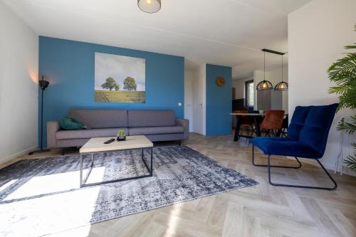 a living room with a couch and a table at Holiday home for the whole family in Ewijk