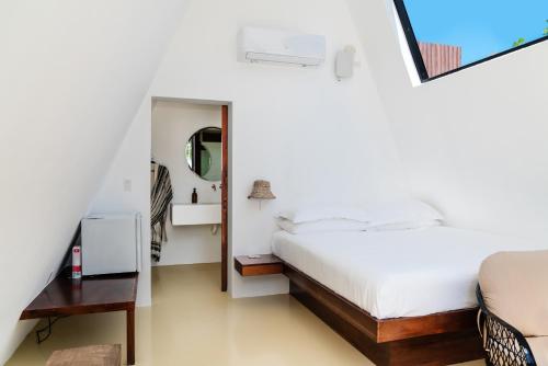 a white bedroom with a bed and a mirror at Sand and Sky Resort Adults Only in Basil Jones