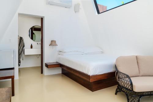 a bedroom with a bed and a chair at Sand and Sky Resort Adults Only in Basil Jones
