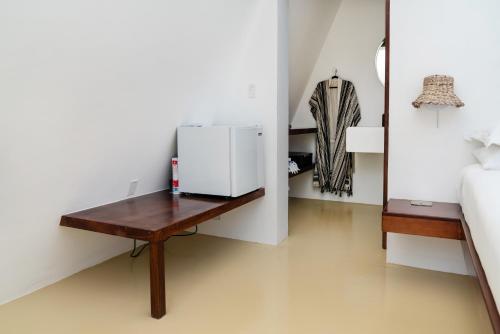 a small white refrigerator on a wooden table in a room at Sand and Sky Resort Adults Only in Basil Jones