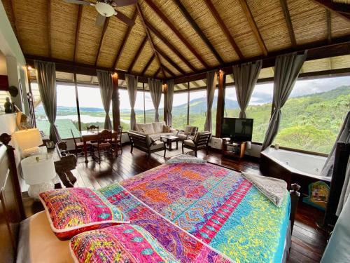 a bedroom with a large bed and a large window at Arenal Birdsong, Entire Villa W- Stunning Views,! in El Castillo de La Fortuna