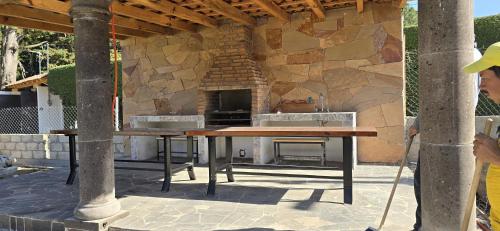 an outdoor kitchen with a table and a stone wall at Cabañas los Cedros in Santiago Oxtempan