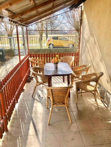 a table and chairs on a balcony with a bus at Sleeps 7 - FamilyFriendly - CloseToLakeBalaton in Mátyásdomb