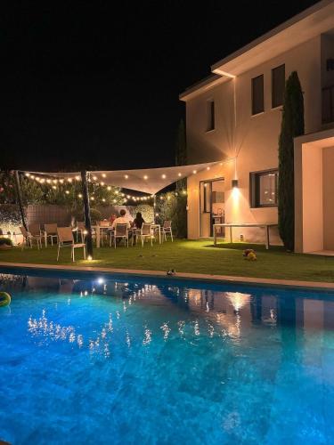 une piscine devant une maison la nuit dans l'établissement Villa de luxe, piscine, plage 7mns, St Tropez 15km, à La Croix-Valmer