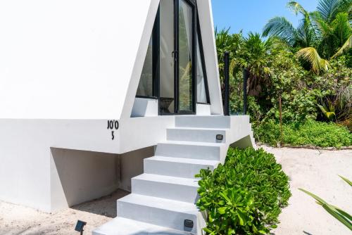a staircase leading up to a house on the beach at Sand and Sky Resort Adults Only in Basil Jones