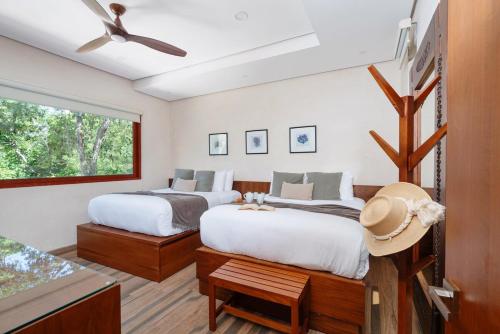 a bedroom with two beds and a window at 9Br Luxury Villas Aldea Zama, Private Pools & Gym! in Tulum