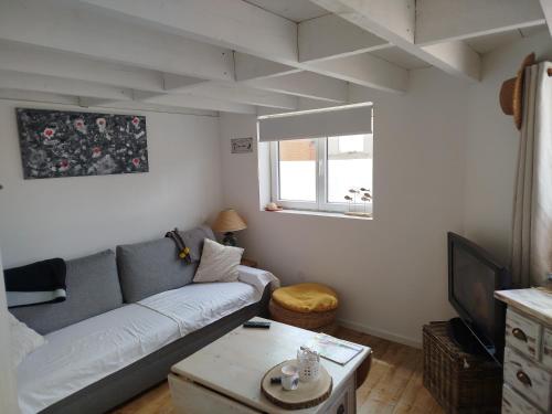 un salon avec un canapé et une table dans l'établissement Escale à Bray Dunes, à Bray-Dunes