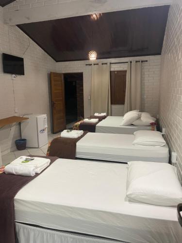 a group of four beds in a room at Pousada Sitio Parque dos Lençóis in Barreirinhas
