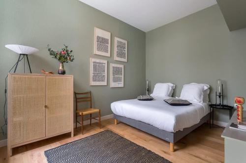 - une chambre avec un lit et une commode fleurie dans l'établissement Arbre sec - Furnished apartment - Downtown Lyon, à Lyon