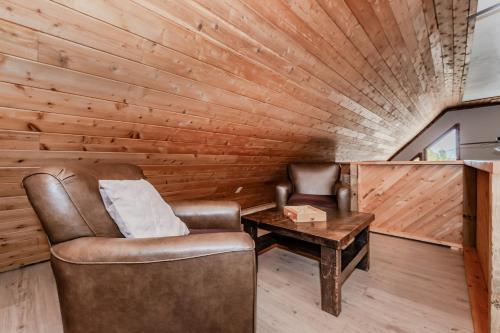 a living room with a chair and a table at Lakeview Loft A-frame Escape Tobermory in Tobermory
