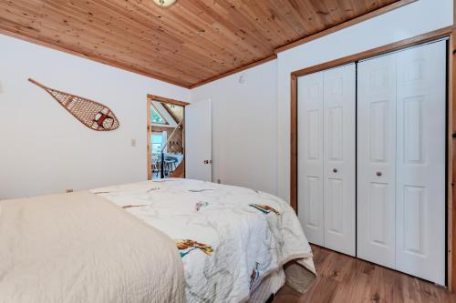 a bedroom with a bed and a wooden ceiling at Lakeview Loft A-frame Escape Tobermory in Tobermory