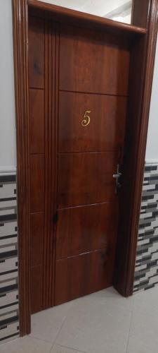 a wooden door with the number on it at Serene BnB - Apt 06 Makongo after Mlimani City in Dar es Salaam