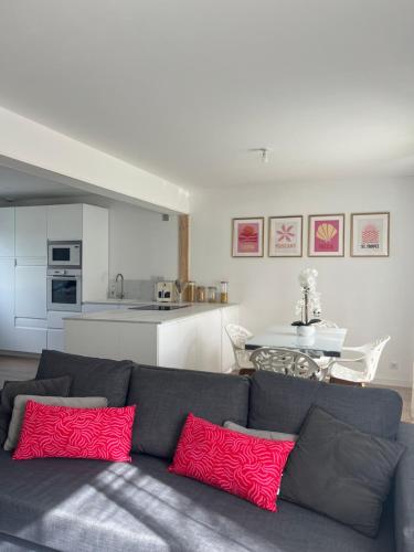 un salon avec un canapé gris avec des coussins rouges dans l'établissement Maison dans le centre de Crozon, à Crozon