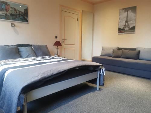 a bedroom with a bed and a couch at Ferienwohnung in einem alten Bauernhaus in Lontzen