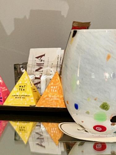 a bowl sitting on top of a shelf with packets at Relais Villa Alma in Castion Veronese