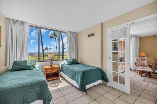 a bedroom with two beds and a window at Kauhale Makai 335 in Kihei