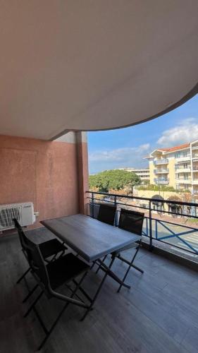 une table et des chaises sur un balcon avec vue dans l'établissement Port Fréjus, Terrasse, wifi, clim, plage à 5', à Fréjus