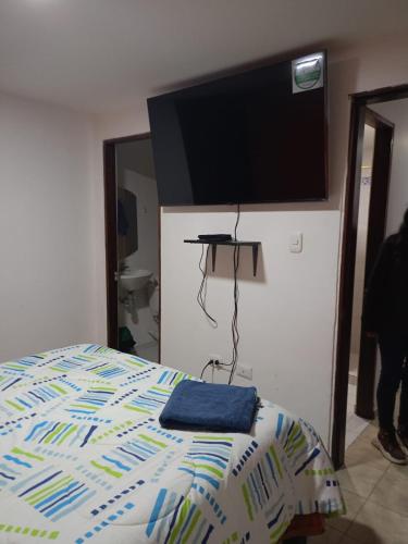a bedroom with a bed with a flat screen tv on the wall at Ipiales puerta de oro in Ipiales