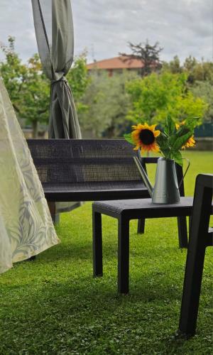 a bench with a vase of flowers on a table at Itaca in Lido di Fermo