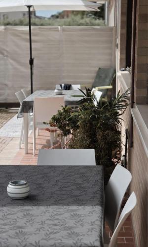 a patio with a table and chairs and an umbrella at Itaca in Lido di Fermo