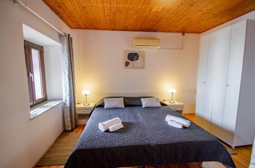 a bedroom with a bed with two towels on it at Village house Kate Dubravica in Dubravica