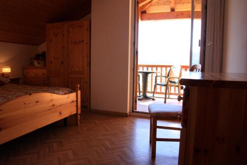 a bedroom with a bed and a balcony at Residence Villa Boschetto in Carano