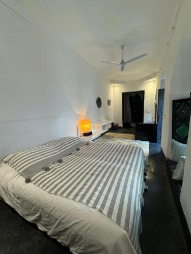 a bedroom with a large bed with a light on it at Riad Maiya in Marrakesh