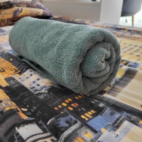 - une serviette verte sur le lit dans l'établissement T5 Lumineux métro à 1min, à Rennes