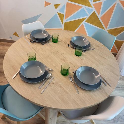 une table en bois avec des assiettes et des verres dans l'établissement T5 Lumineux métro à 1min, à Rennes