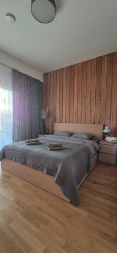 Un dormitorio con una cama grande con una pared de madera. en Storms 4, en Sudmalkalni