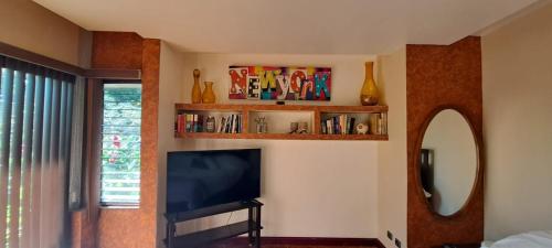 a living room with a flat screen tv and a mirror at Bed and breakfast close to airport, beaches and attractions in Alajuela City