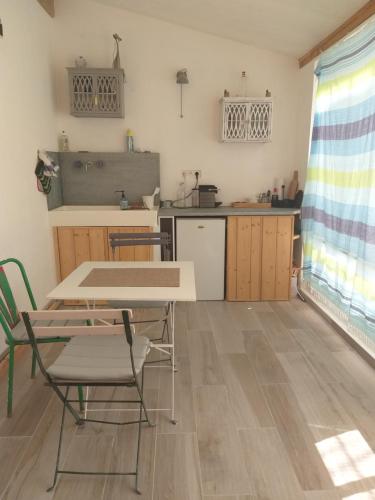 une cuisine avec une table et des chaises dans une pièce dans l'établissement Authentique maison de pêcheur, au Grau-du-Roi